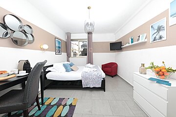 A bedroom with a single bed a chair and a dresser