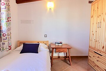 A bedroom with a single bed and a curtain that says spring