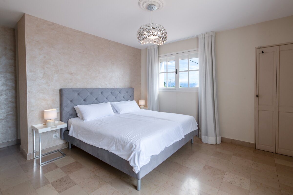 A bedroom with a large bed and a window