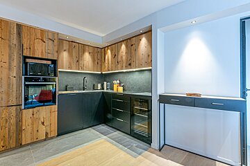 A kitchen with wooden cabinets and black appliances including a microwave