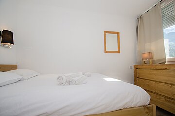 A bedroom with a bed and a mirror on the wall