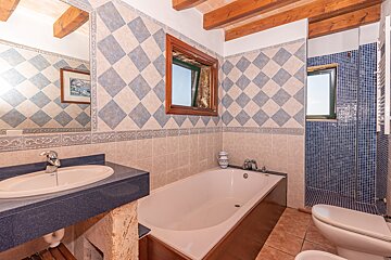 A bathroom with blue and white tiles and a bathtub