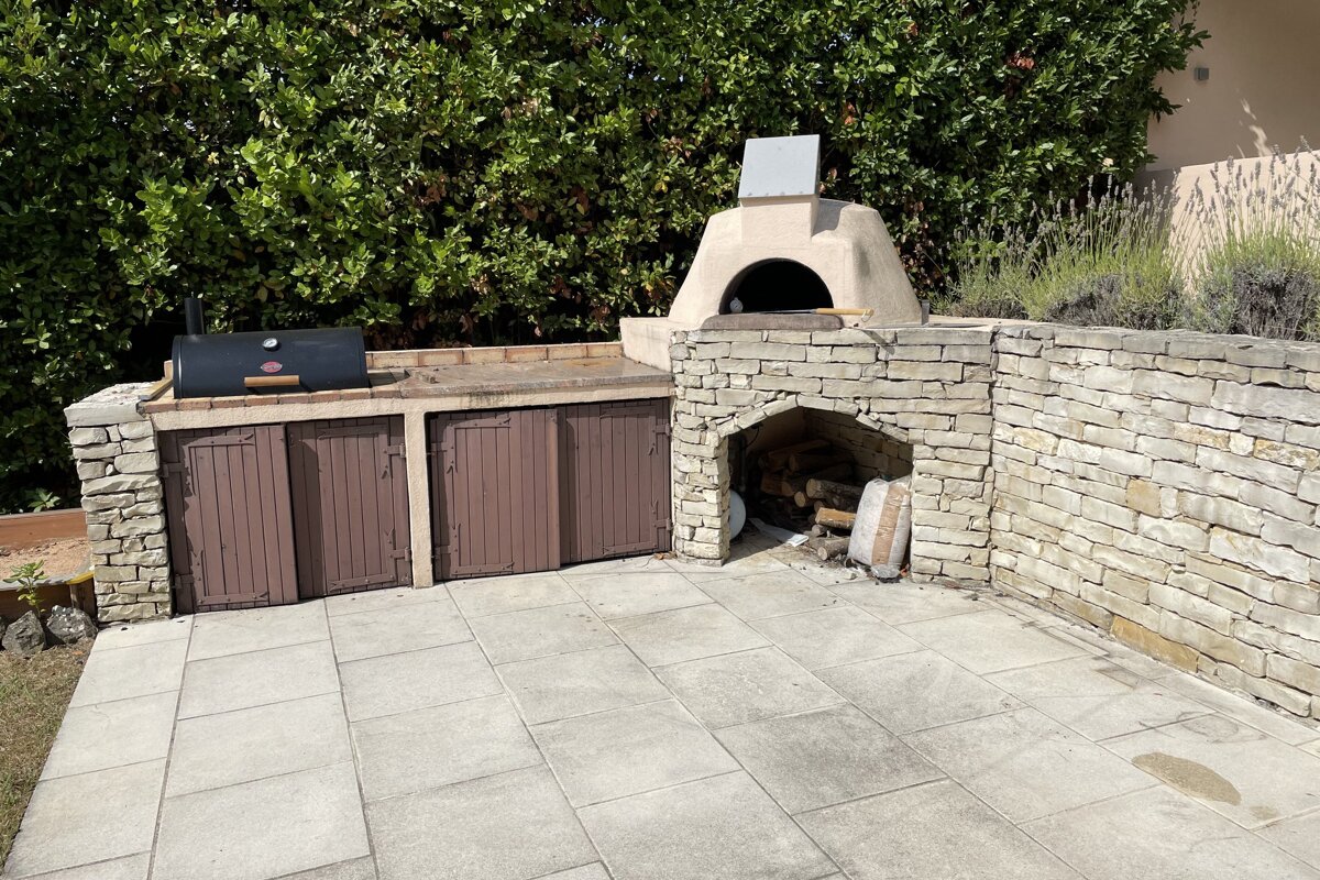 A patio area with a grill and a stone oven