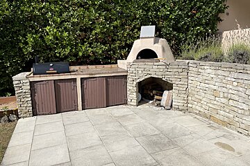A patio area with a grill and a stone oven