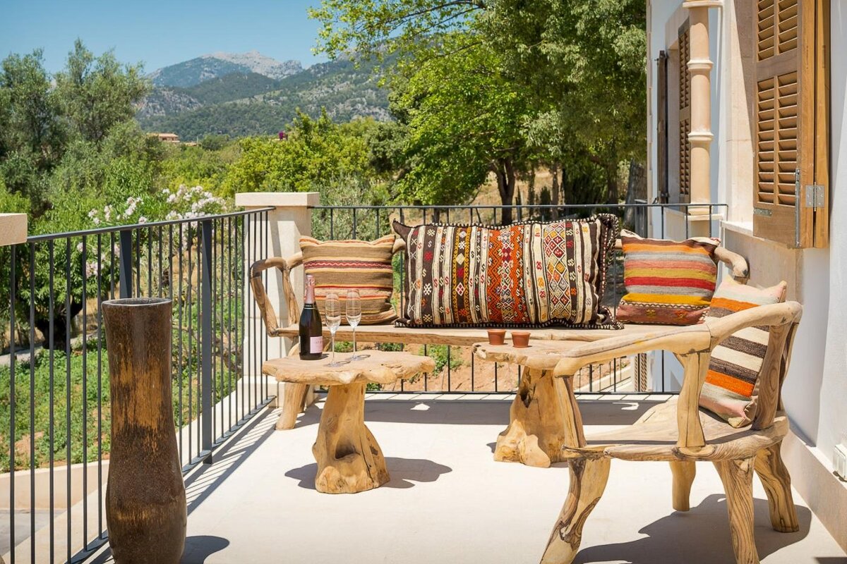 A bottle of wine sits on a table on a balcony