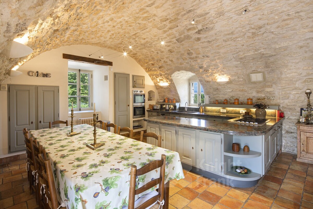 A kitchen with a table and chairs and the word cuisine on the wall