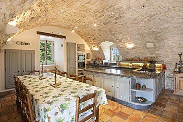 A kitchen with a table and chairs and the word cuisine on the wall
