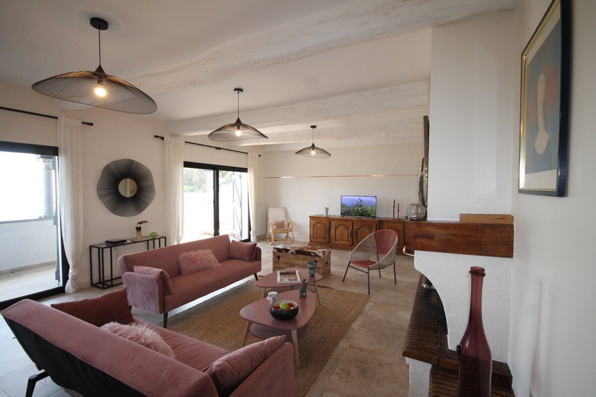 A living room with a pink couch and a fireplace