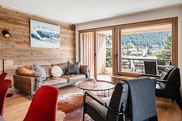 A living room with a couch and chairs and a painting on the wall
