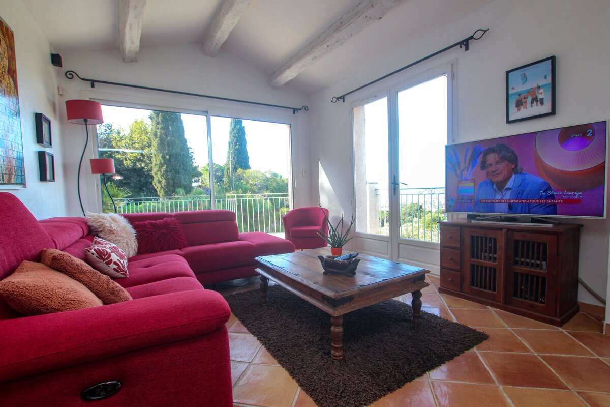 A living room with a red couch and a flat screen tv