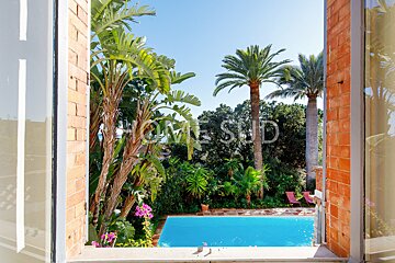 A view of a swimming pool from a window that says home sud