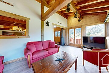 A living room with a red couch and a flat screen tv