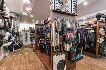 A store filled with lots of clothes and hats including a hat that says ' salomon ' on it