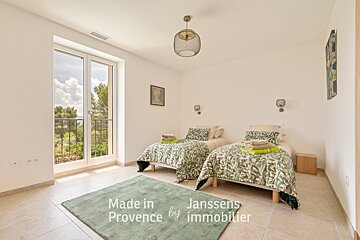 A bedroom with two beds made in provence by immobilier