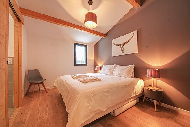 A bedroom with a painting of a bull on the wall