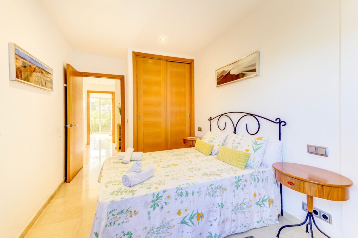 A bedroom with a large bed and a small table