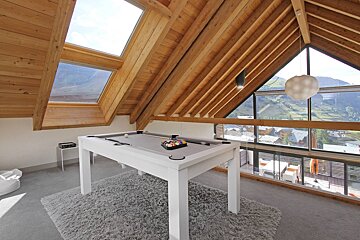 A pool table in a room with a view of the mountains