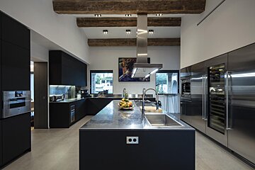 A kitchen with black cabinets and stainless steel appliances