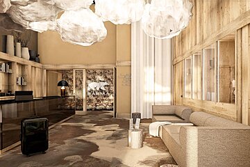 A hotel lobby with a couch and a suitcase