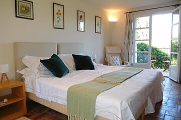 A bedroom with a large bed and a chair