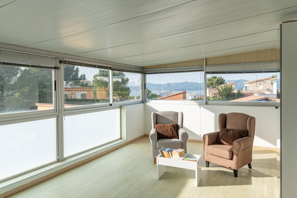 A living room with two chairs and a table with books on it