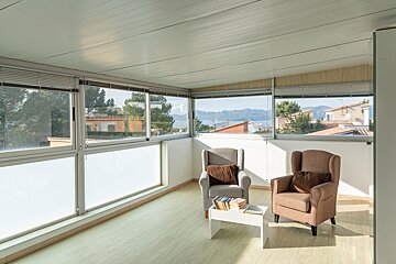 A living room with two chairs and a table with books on it