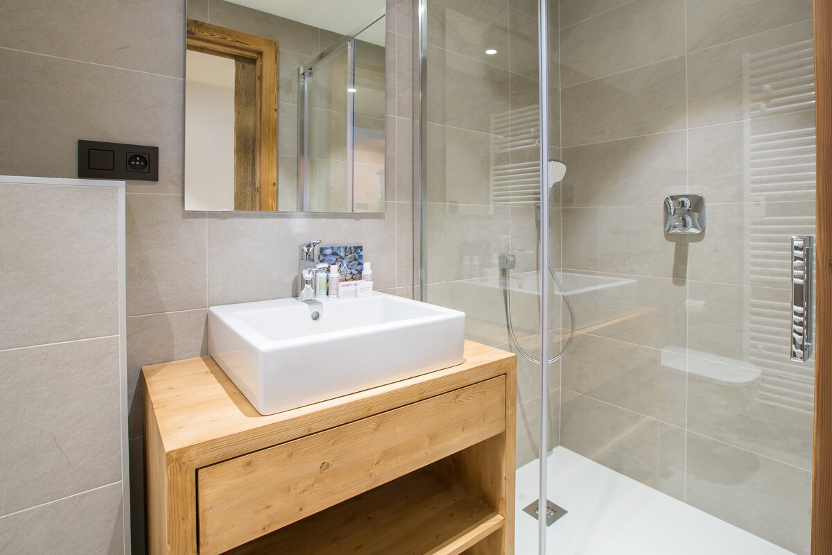A bathroom with a sink and a walk in shower
