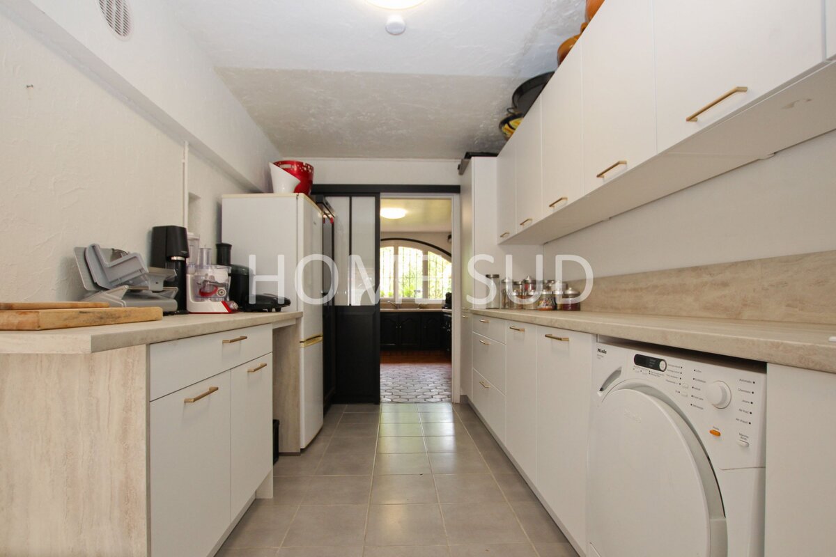 A kitchen with white cabinets and a washer and dryer and the words home sud on the counter