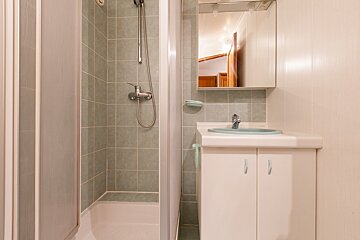 A bathroom with a sink and a walk in shower