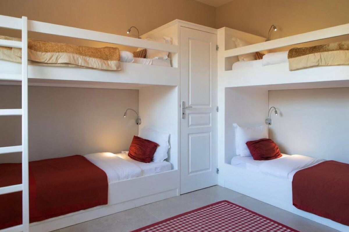 Four bunk beds in a room with a checkered rug