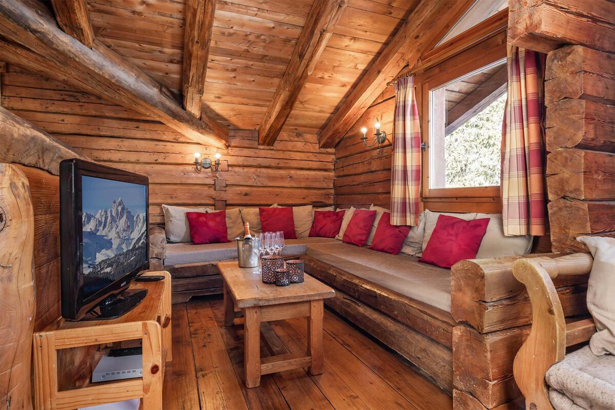 A living room in a log cabin with a flat screen tv