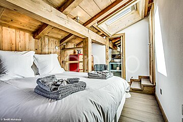 A bedroom with a bed and a skylight taken by ten80 holidays