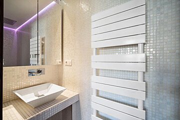 A bathroom with a square sink and a white towel rack