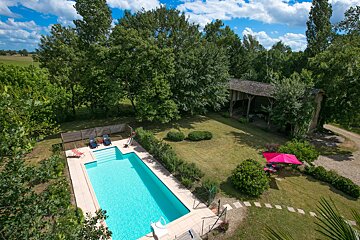 An aerial view of a large swimming pool surrounded by trees