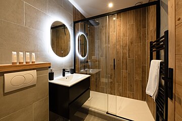 A bathroom with a sliding glass shower door