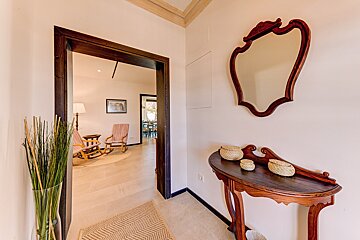 A hallway with a wooden table and a mirror