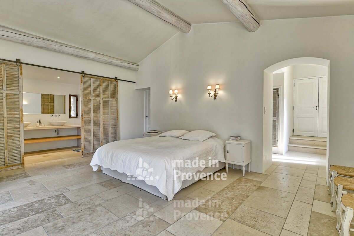 A bedroom with a bed and shutters that say made in provence