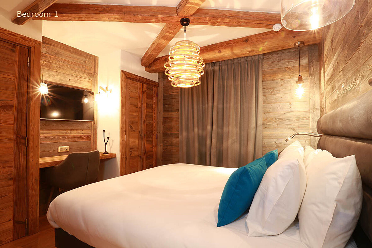 A bedroom with a king size bed and a flat screen tv