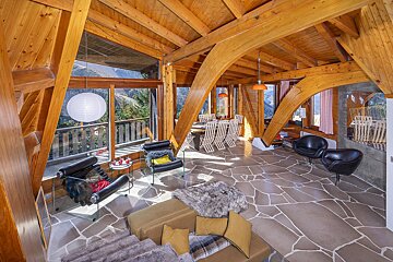 A living room with a stone floor and wooden beams