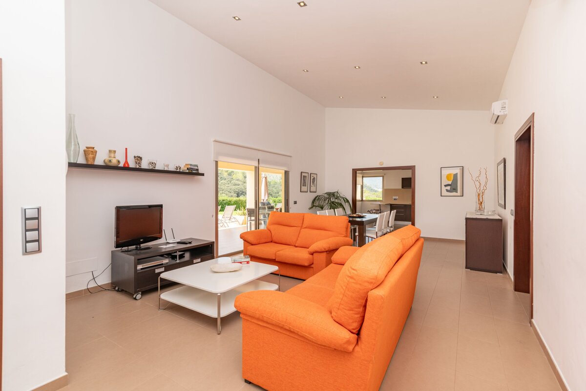 A living room with orange furniture and a flat screen tv