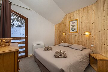 A bedroom with a bed and a picture of butterflies on the wall