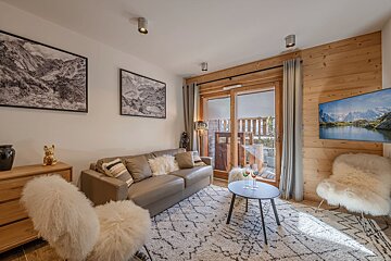A living room with a couch and a table with a bottle of champagne on it