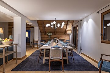 A dining room with a long table and chairs