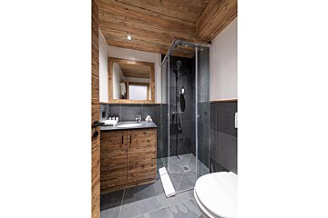 A bathroom with a walk in shower and a sink