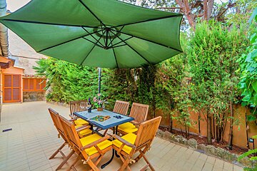 A table and chairs under an umbrella on a patio