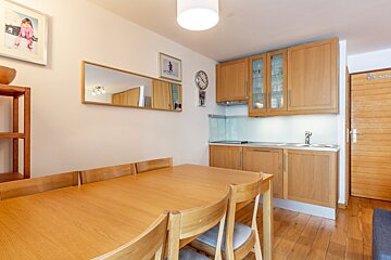A kitchen with a sink and a clock on the wall