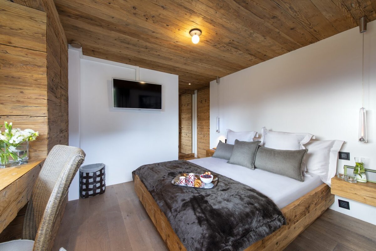 A bedroom with a wooden bed and a flat screen tv