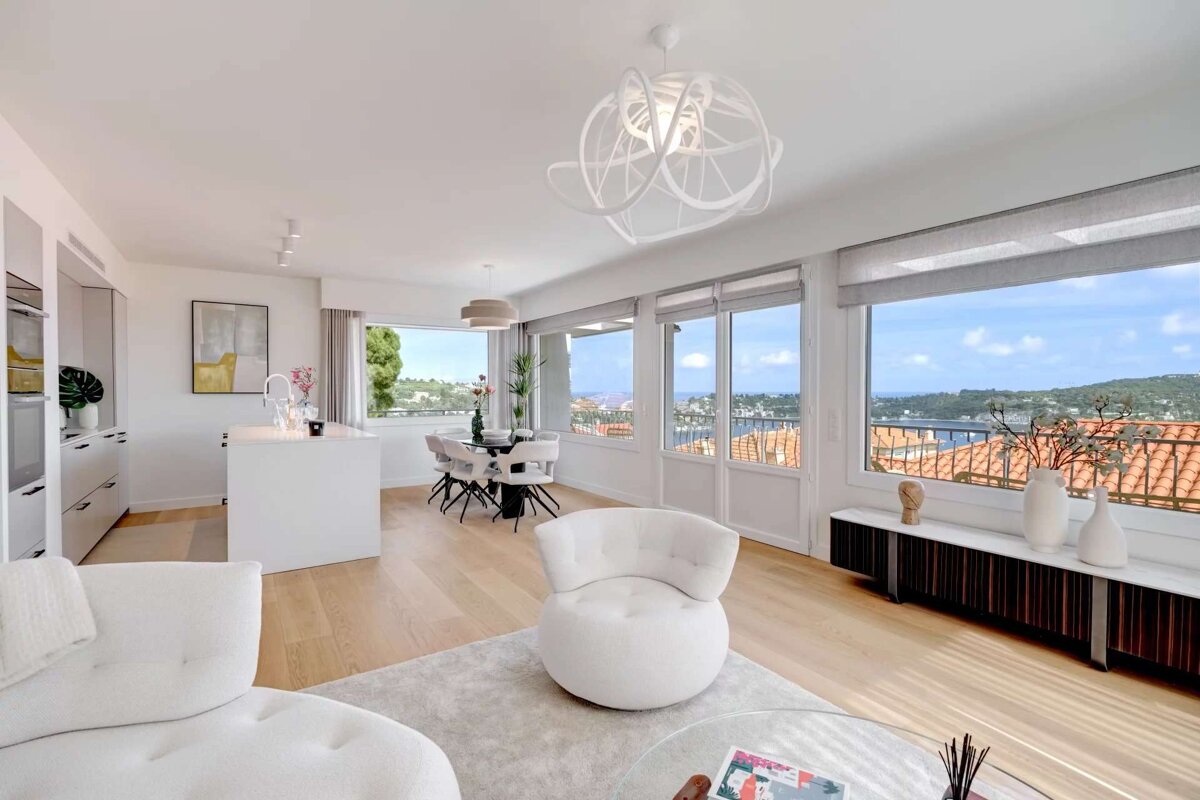 A living room with white furniture and a large window