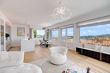 A living room with white furniture and a large window