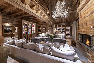 A living room with a large sectional couch and a fireplace